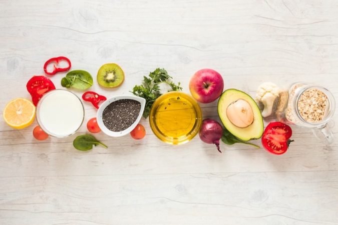 Une sélection d'ingrédients frais et nutritifs sur un fond en bois clair pour réussir son Batch cooking petit budget : 5 repas équilibrés pour 20€ par semaine (Liste de courses incluse).