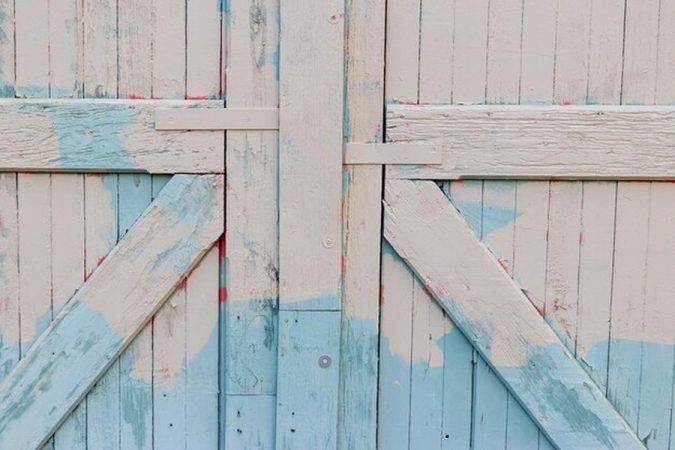 Un vieux revêtement en bois à la peinture bleue et blanche écaillée illustre l'intérêt de savoir comment peindre du lambris sans poncer : la méthode étape par étape pour moderniser une pièce sans effort.