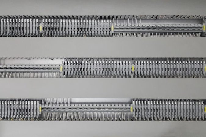 Un tableau électrique aux câblages parfaitement alignés illustrant comment rénover l'électricité d'une maison ancienne sans faire de saignées.