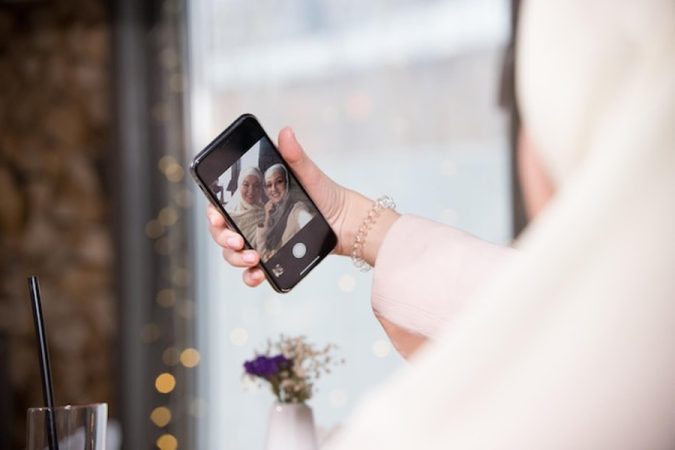 Une main saisit un moment de bonheur sur un smartphone, démontrant l'expertise d'un Wedding Content Creator : Pourquoi engager ce nouveau prestataire et comment choisir le bon pour ses réseaux sociaux ?