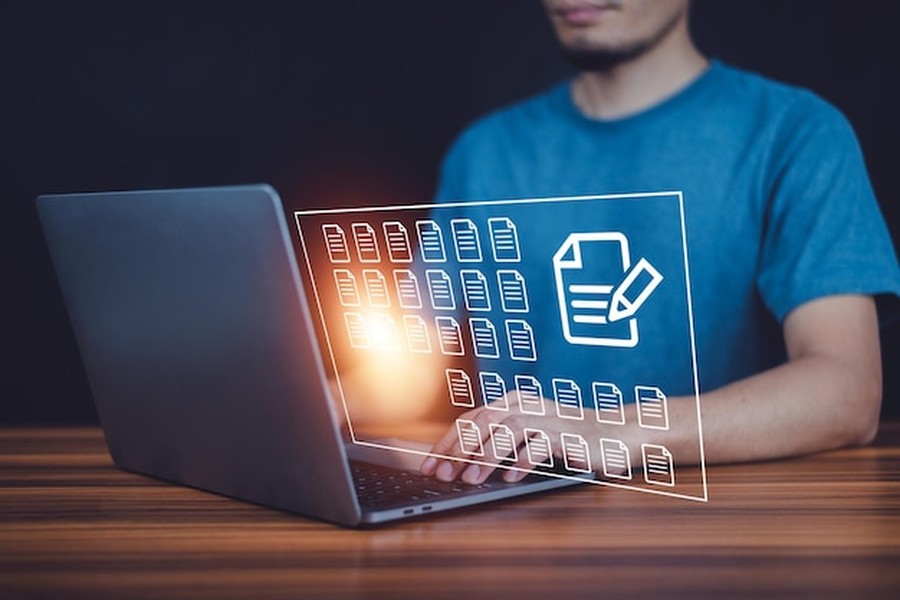 Un professionnel gère une base de données numérique sur son ordinateur pour comprendre comment adapter vos fiches produits aux nouveaux algorithmes d'achat autonomes.