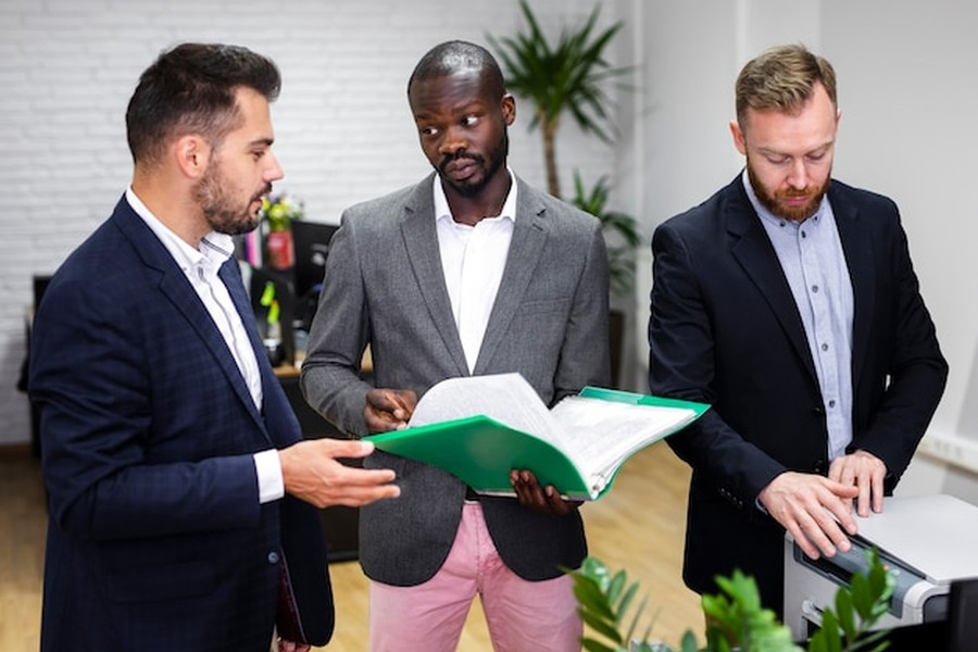 Trois professionnels du droit analysant des documents pour contester un PV de Zone à Faibles Émissions : les arguments juridiques qui marchent.