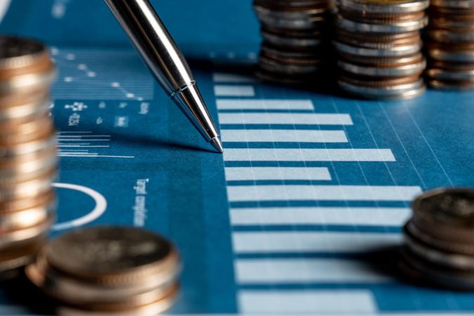 Analyse de données financières et calcul des Grecques des Options sur un graphique de performance avec des piles de pièces de monnaie