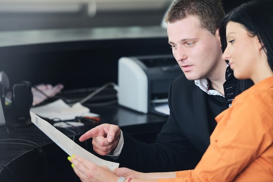 Deux collaborateurs analysent un document stratégique sur comment optimiser son catalogue produit pour les moteurs de réponse et agents d'IA personnels.