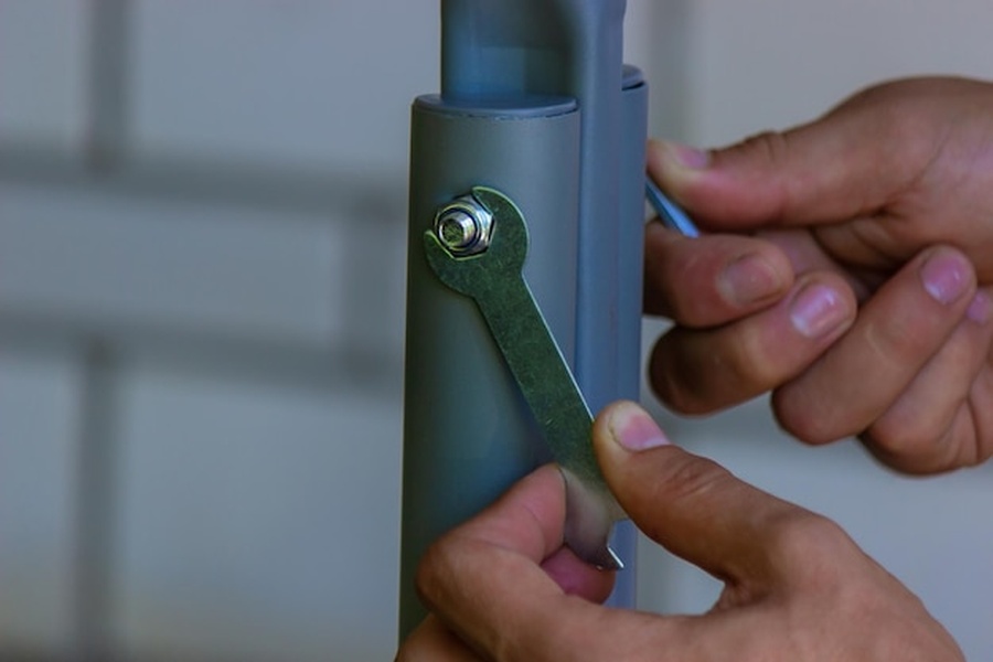 Mains manipulant une clé métallique sur un dispositif de sécurité pour comprendre comment ouvrir une serrure connectée en cas de panne de batterie ou de bug.