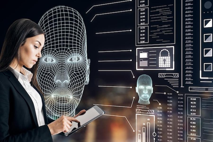 Une experte en cybersécurité analyse des données biométriques sur une interface numérique pour comprendre comment assurer son identité numérique contre les fraudes par IA et Deepfakes.