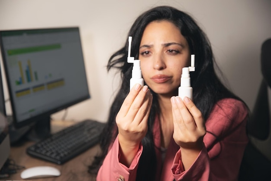 Une femme au bureau compare deux produits de soin pour le visage afin de comprendre comment adapter sa communication non-verbale aux filtres de correction faciale en temps réel.