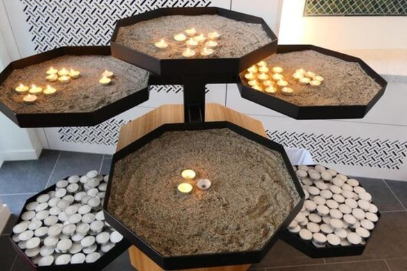 Plusieurs bougies chauffe-plat brillent dans des réceptacles de sable hexagonaux, évoquant la tranquillité d'esprit lorsqu'on sait comment protéger ses fondations contre le retrait-gonflement des argiles avec les normes 2026.