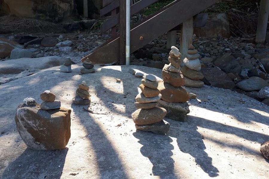 Des cairns de pierres en équilibre sur une surface solide pour illustrer comment protéger ses fondations contre le retrait-gonflement des argiles avec les normes 2026.