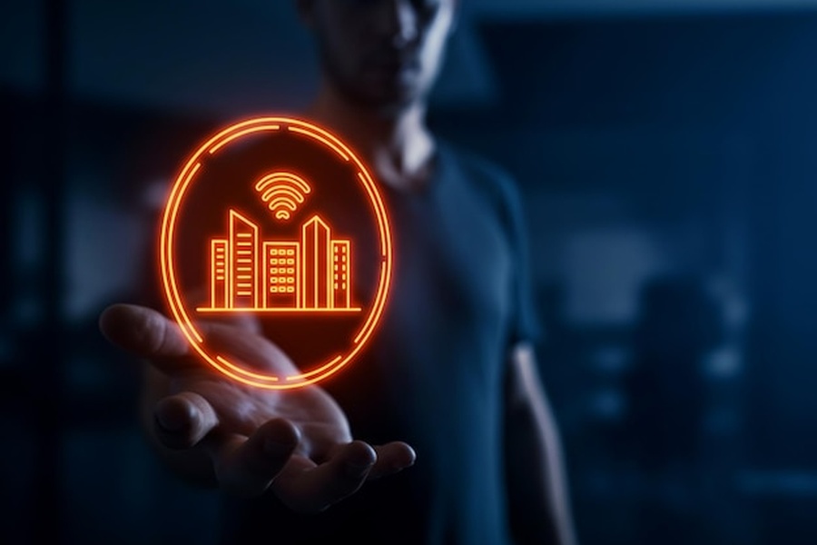 Un hologramme orange représentant une ville intelligente lévitant au-dessus d'une main pour illustrer comment configurer un réseau local Matter sans hub propriétaire pour sécuriser sa maison connectée.
