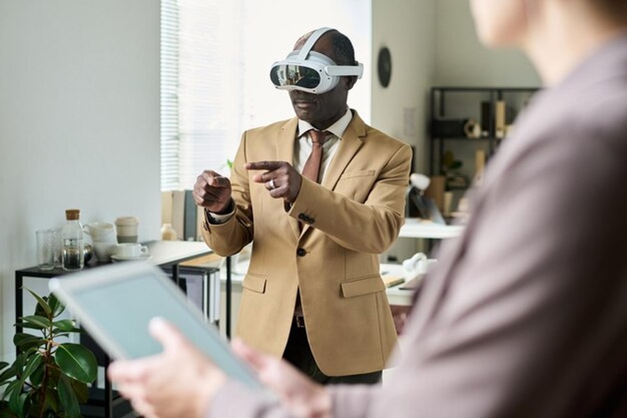 Un professionnel en costume beige utilise un casque de réalité mixte dans un bureau moderne pour analyser comment convaincre les agents IA personnels d'afficher vos publicités à leurs utilisateurs.