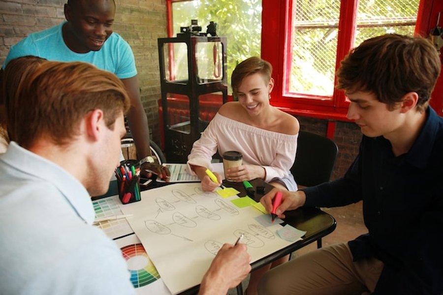 Étudiants collaborant activement sur un schéma conceptuel pour optimiser l'inclusion des élèves DYS : Guide des agents IA d'assistance pédagogique en temps réel.