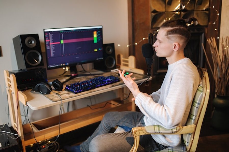 Un créateur sonore devant son écran de monitoring expliquant comment configurer un home studio pour le mixage en audio spatial à petit budget.