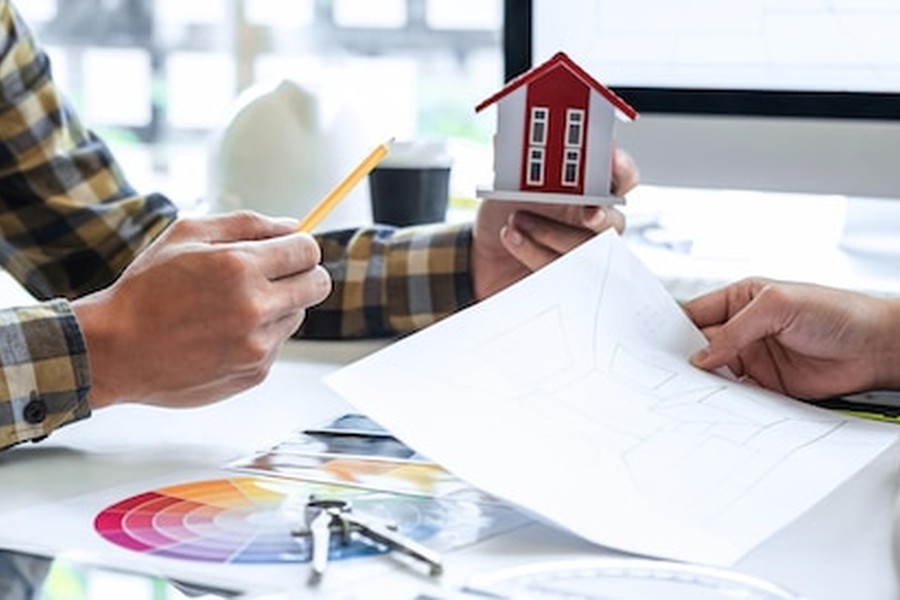 Un expert immobilier et un propriétaire étudient des plans de travaux pour tout savoir sur le nouveau permis de louer thermique 2026 : obligations et solutions de rénovation.