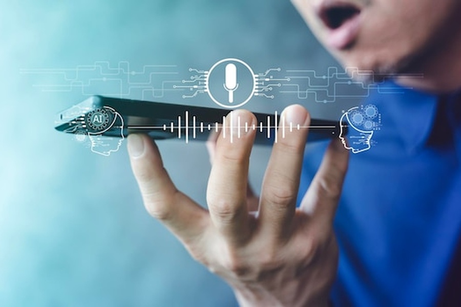 Un utilisateur tenant un smartphone affichant des ondes sonores numériques pour apprendre comment protéger son identité numérique contre l'usurpation par clone vocal.