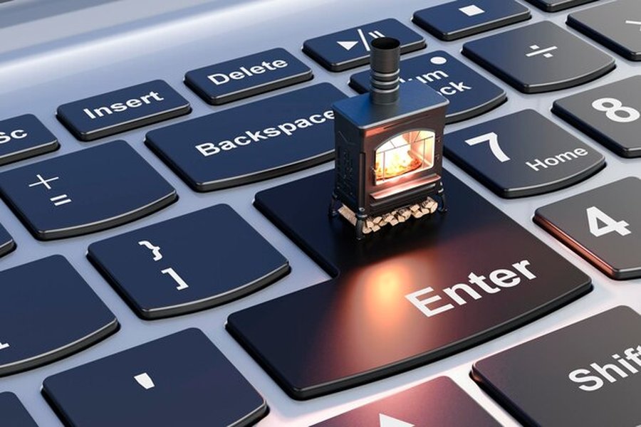 Un petit poêle à bois chaleureux posé sur la touche Entrée d'un clavier, expliquant comment bloquer l'indexation de vos fichiers privés par l'IA de votre ordinateur.