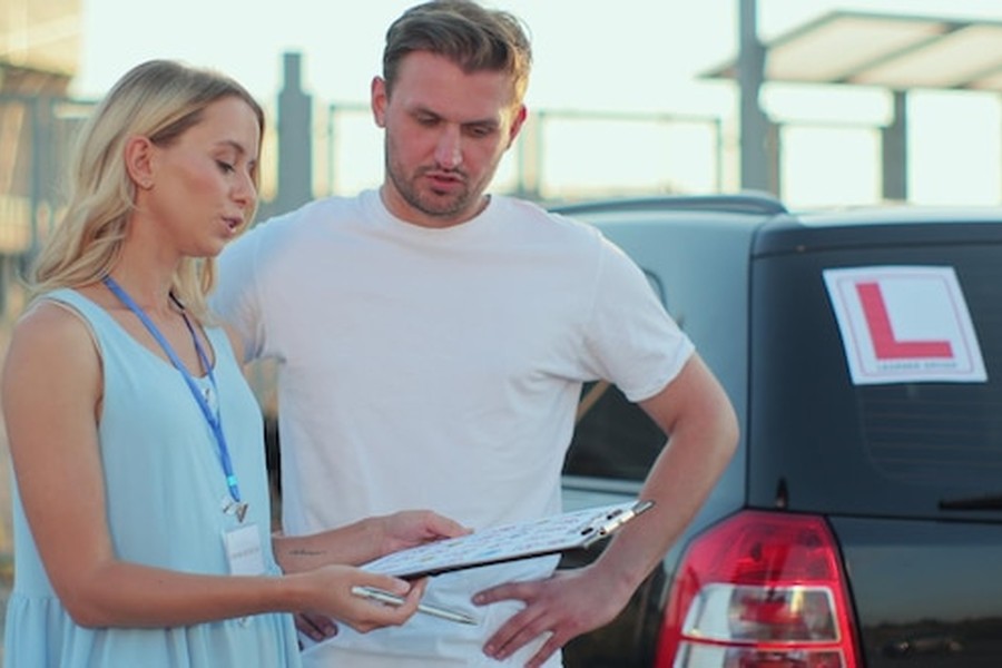 Une experte et un conducteur étudient comment faire homologuer le rétrofit de sa voiture diesel pour rouler en ZFE en 2026 lors d'un contrôle de conformité.