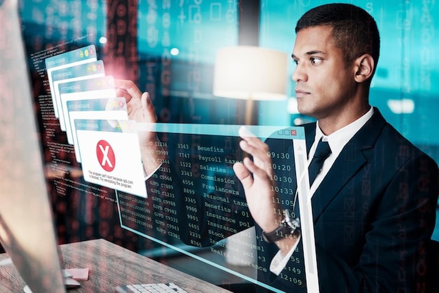 Un professionnel analyse des alertes de sécurité sur un écran holographique pour comprendre comment se faire rembourser une escroquerie au deepfake par son assurance cyber.