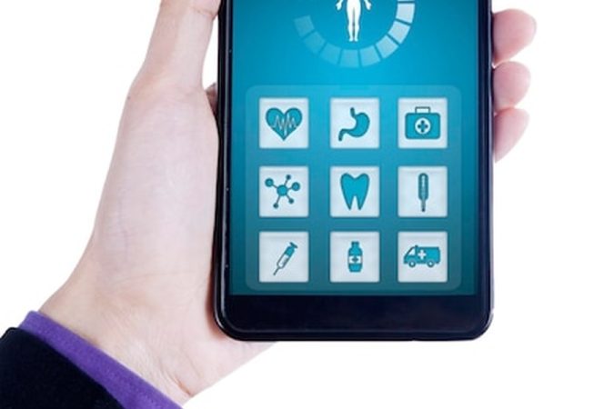 Une main tient un smartphone affichant une interface de g p s santé avec des icônes médicales variées.