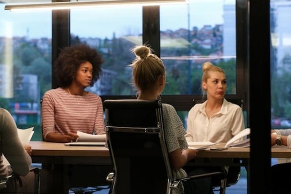 Trois professionnelles attentives lors d'une session de formation intelligence artificielle nexa dans un bureau moderne.